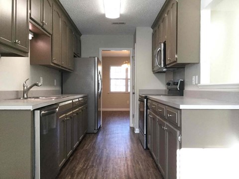 A kitchen with brown cabinets and a white counter.