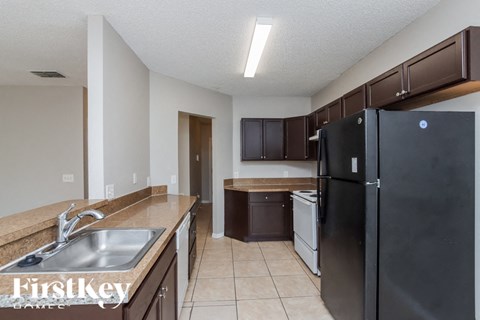 a kitchen with a black refrigerator and a sink