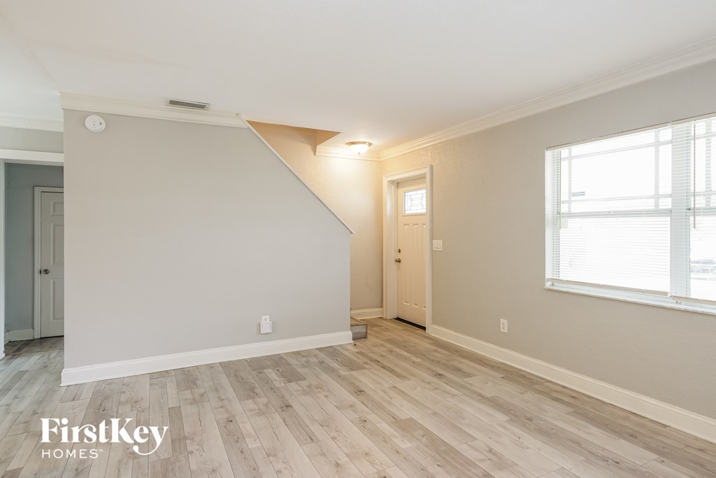 the living room and dining room with hardwood floors and white walls