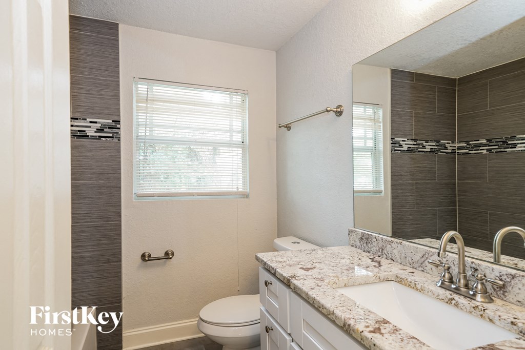 a bathroom with a toilet and a sink and a mirror