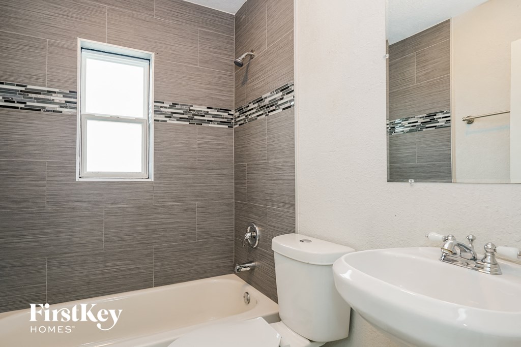a bathroom with a toilet sink and tub and a window