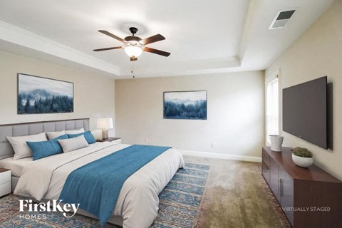 A bedroom with a large bed and a flat screen TV mounted on the wall.