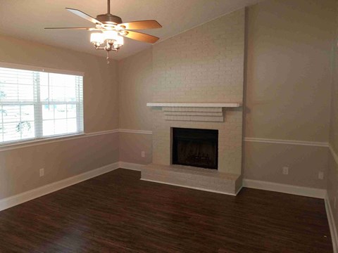 A room with a fireplace and a ceiling fan.