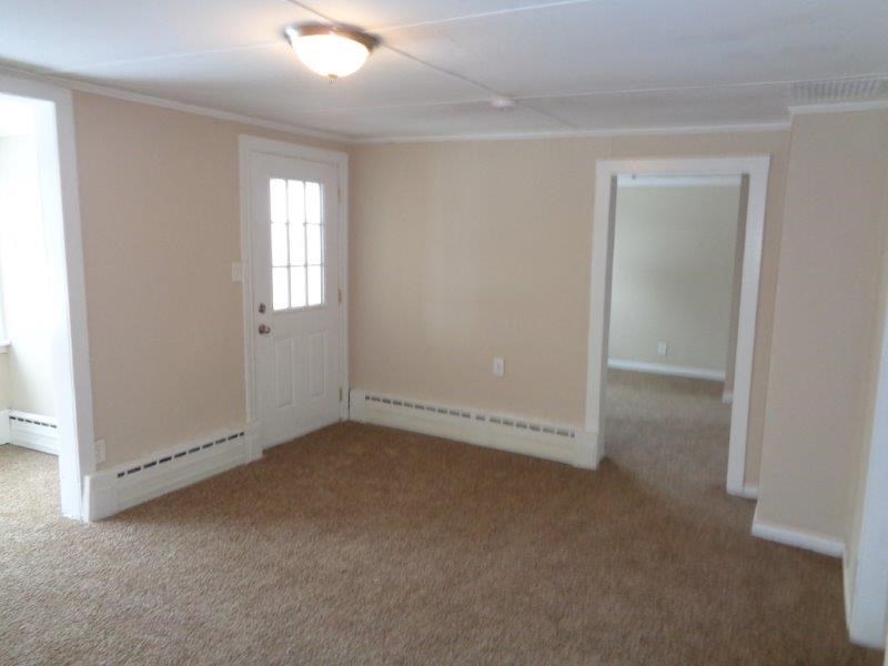 A room with a carpeted floor and a window.