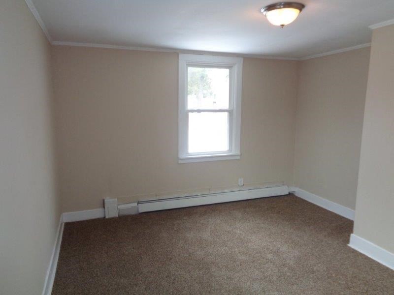 A room with a window and carpeted floor.
