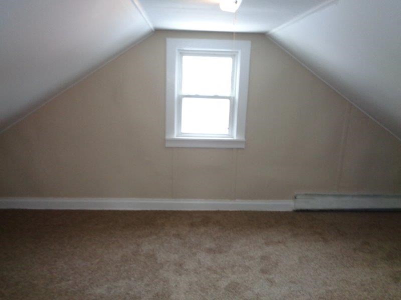 A small window in a room with a carpeted floor.