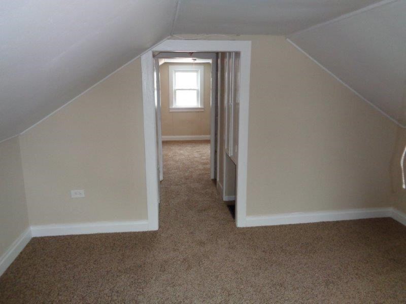 A room with a carpeted floor and a window.