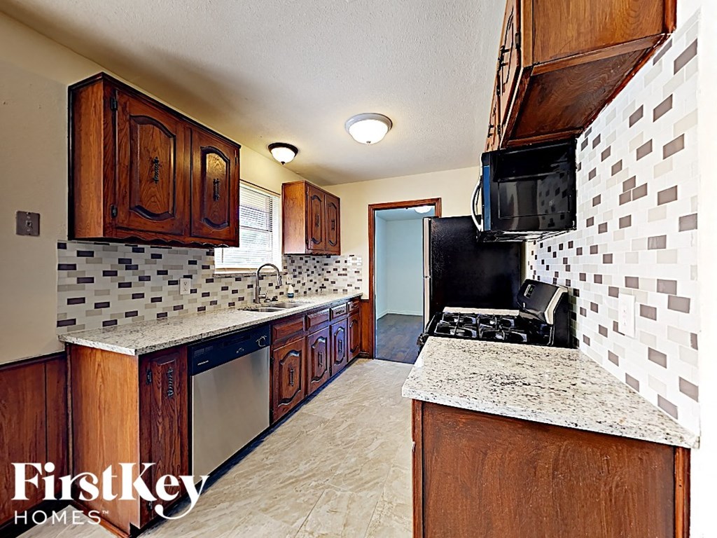 A kitchen with wooden cabinets and a black stove top oven.