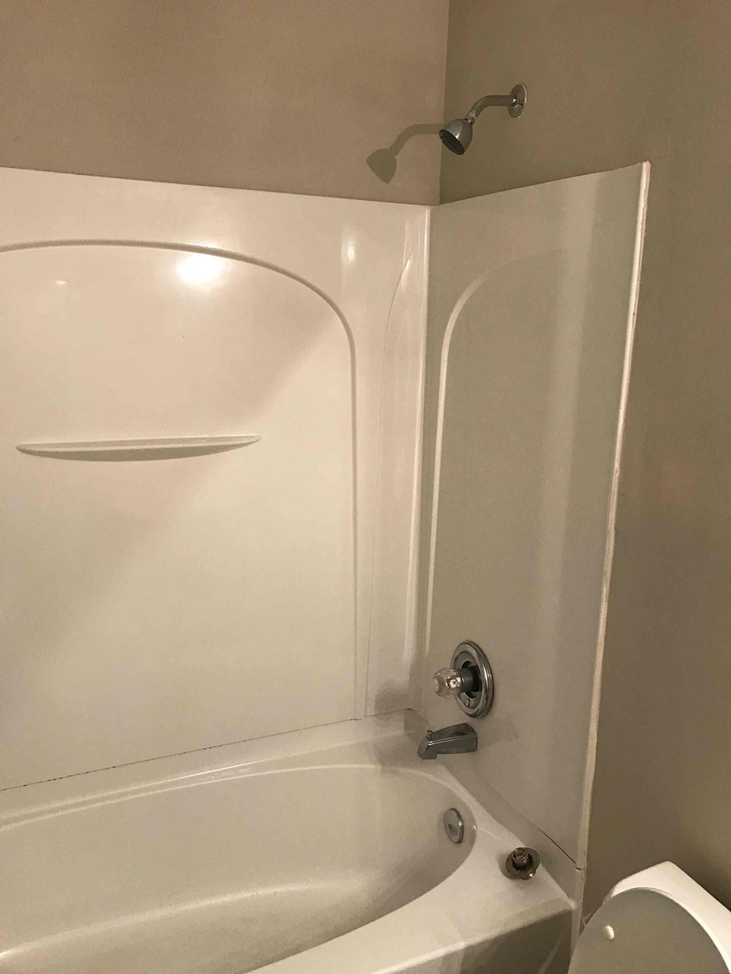 a white bathroom with a tub and a toilet