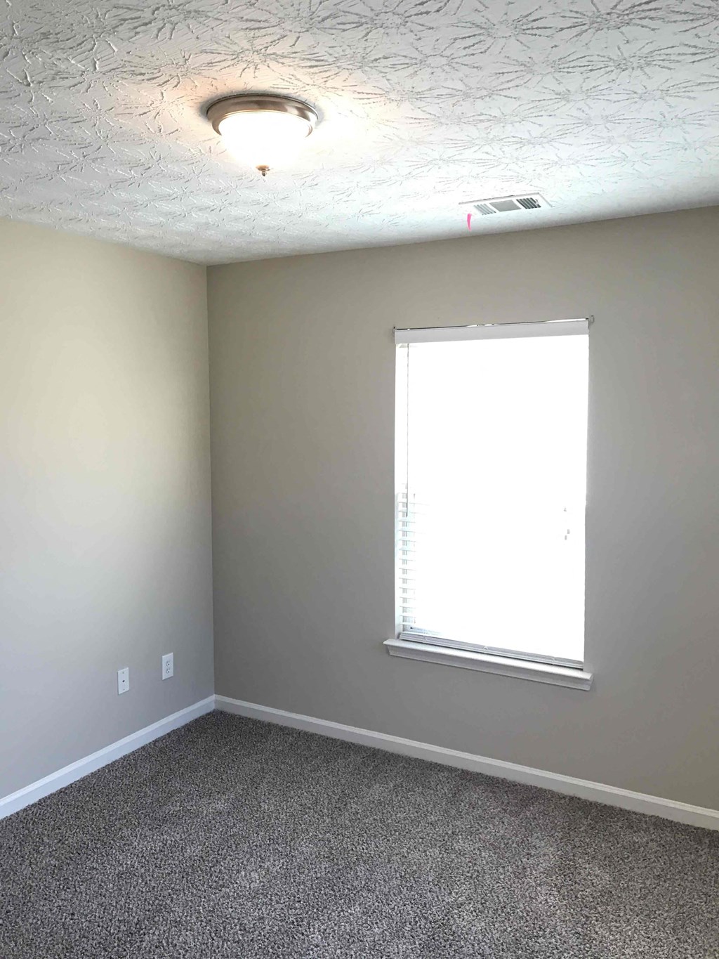 a room with a window and a carpet