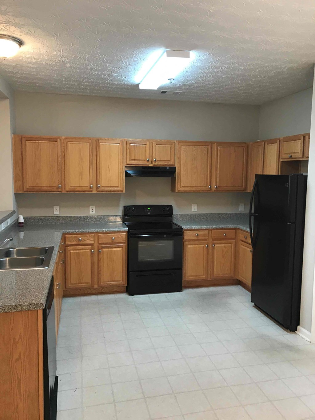a kitchen with black appliances and wooden cabinets