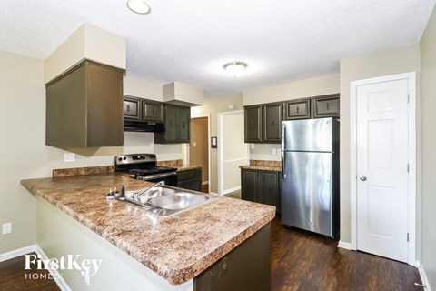 a kitchen with granite counter tops and a stainless steel refrigerator