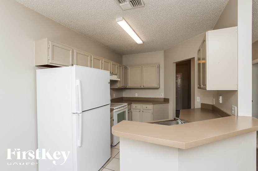 A kitchen with a white refrigerator and a sink.