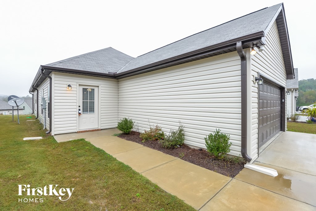 the front of a white house with a driveway and a garage door