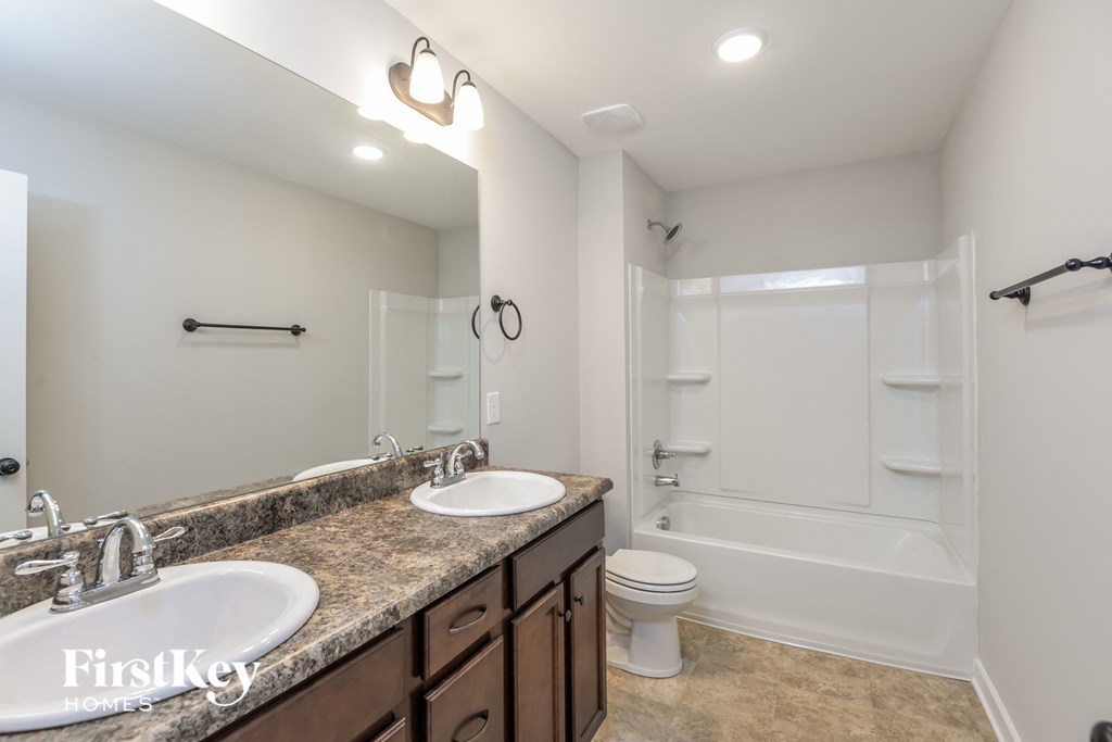 a bathroom with two sinks and a shower and a toilet