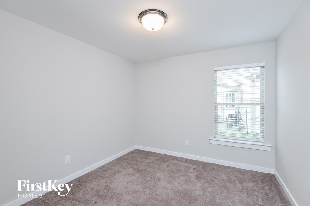 a bedroom with a carpeted floor and a window