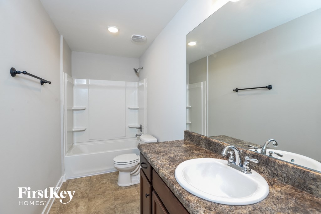 a bathroom with a sink and a shower and a toilet