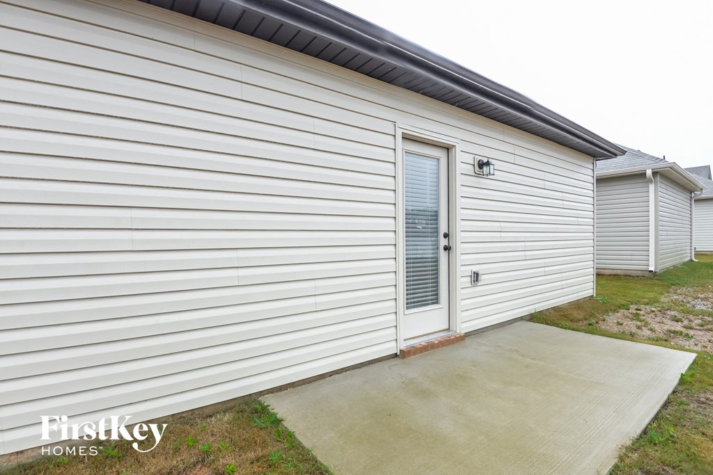 the side of a white house with a garage door