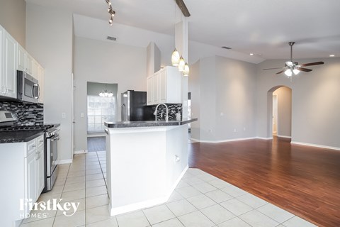 A kitchen with white cabinets and a black countertop.