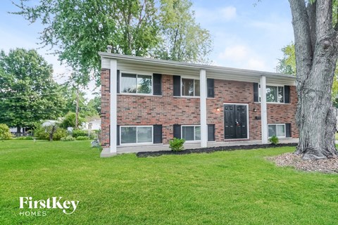 A brick house with a tree in front of it.