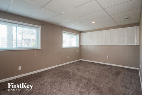 A room with a carpeted floor and a wall of windows.