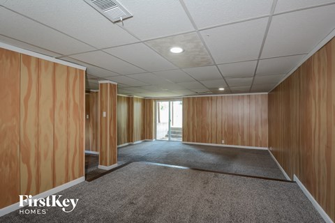 A spacious room with wooden walls and a carpeted floor.