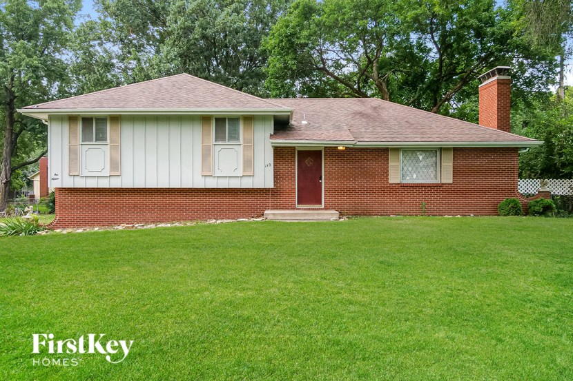 A red brick house with a white door and windows.