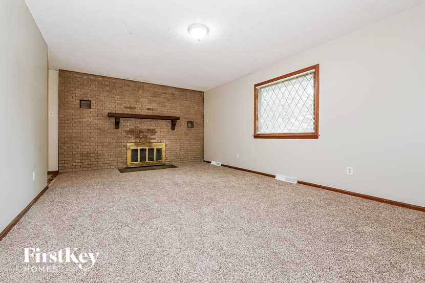 A room with a brick fireplace and a window.