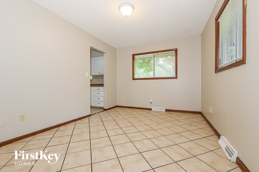 A room with a tiled floor and a window with a view of trees.