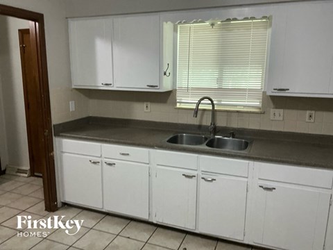 A kitchen with white cabinets and a sink.