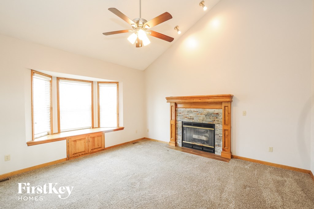 a living room with a fireplace and a ceiling fan