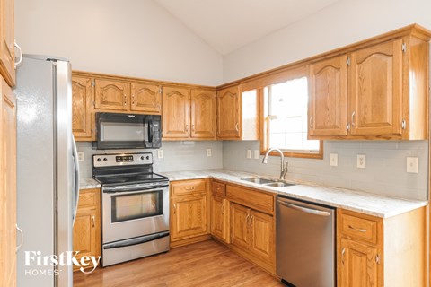 a kitchen with wooden cabinets and stainless steel appliances