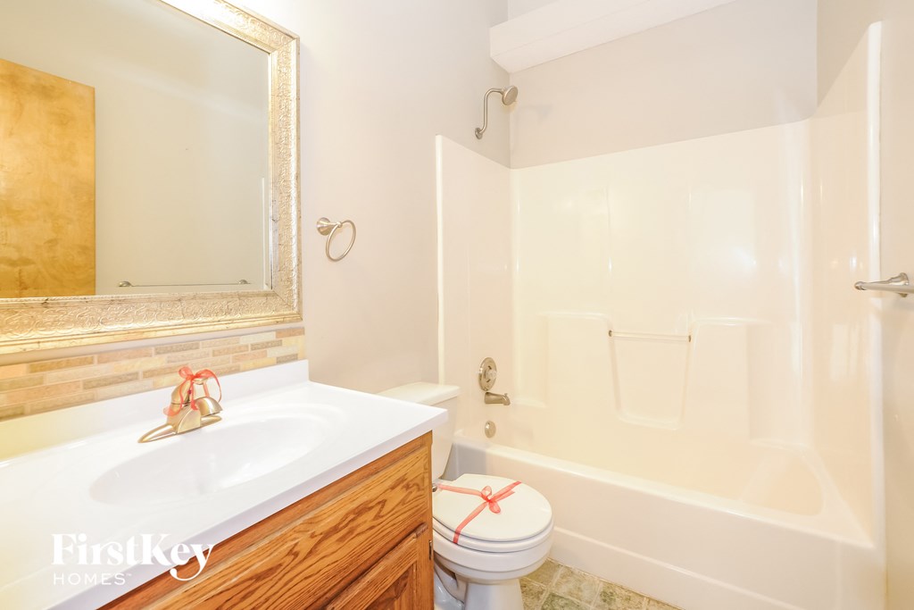 a bathroom with a toilet and a tub and a sink