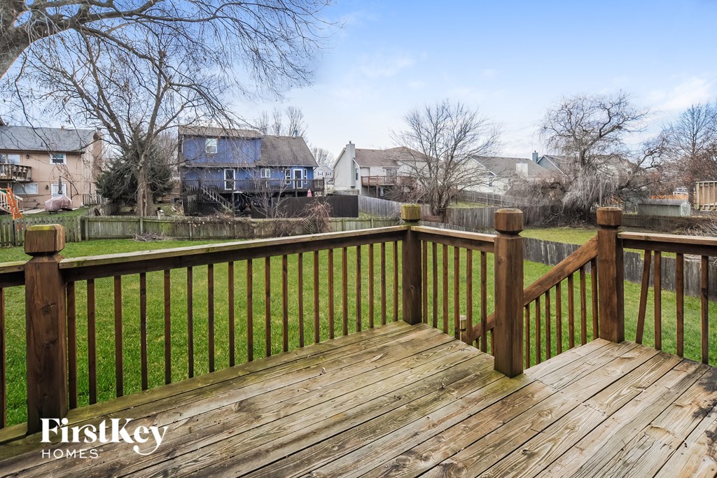a backyard deck with a yard and houses in the background