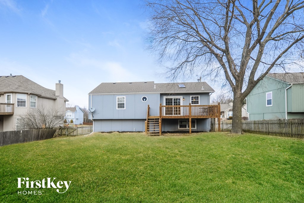 a blue house with a backyard and a deck