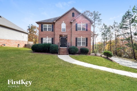 a brick house with a sidewalk in front of it