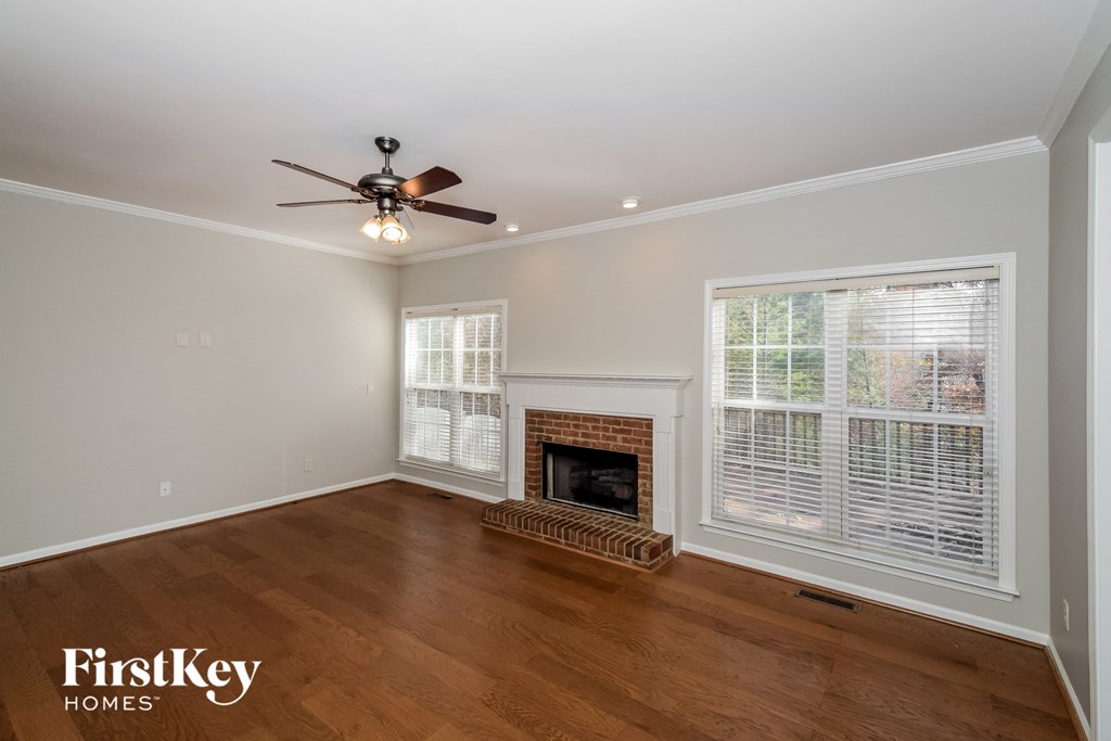 a living room with a fireplace and a ceiling fan