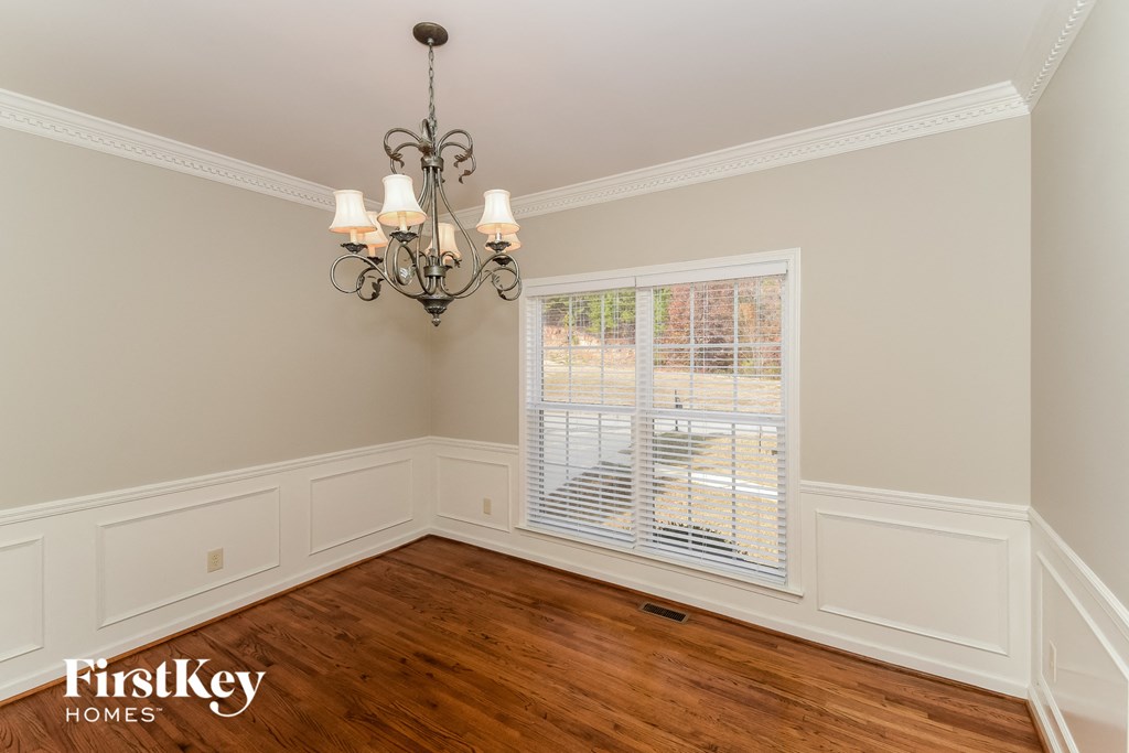 a dining room with wood floors and a large window