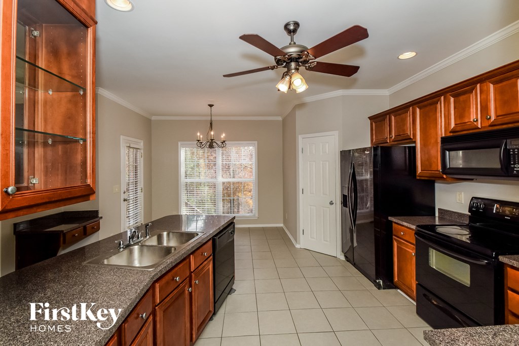 a kitchen with a sink and a ceiling fan