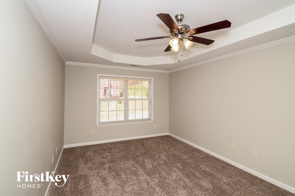 a bedroom with carpet and a ceiling fan