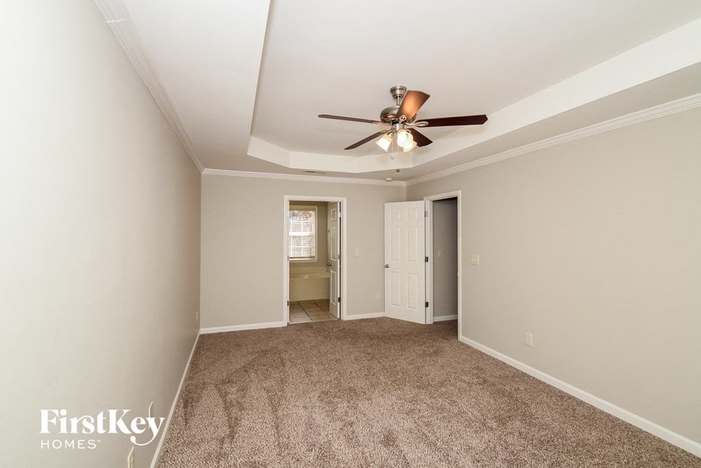 a living room with carpet and a ceiling fan