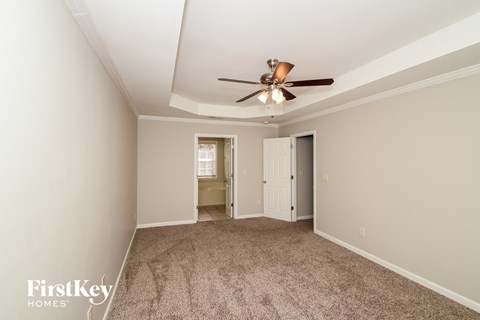 a living room with carpet and a ceiling fan