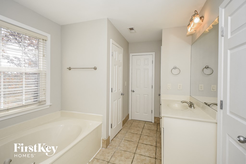 a bathroom with a tub and a sink and a window