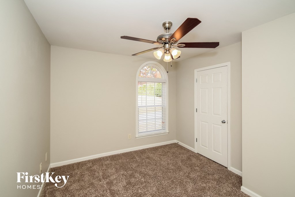 a bedroom with a ceiling fan and a white door