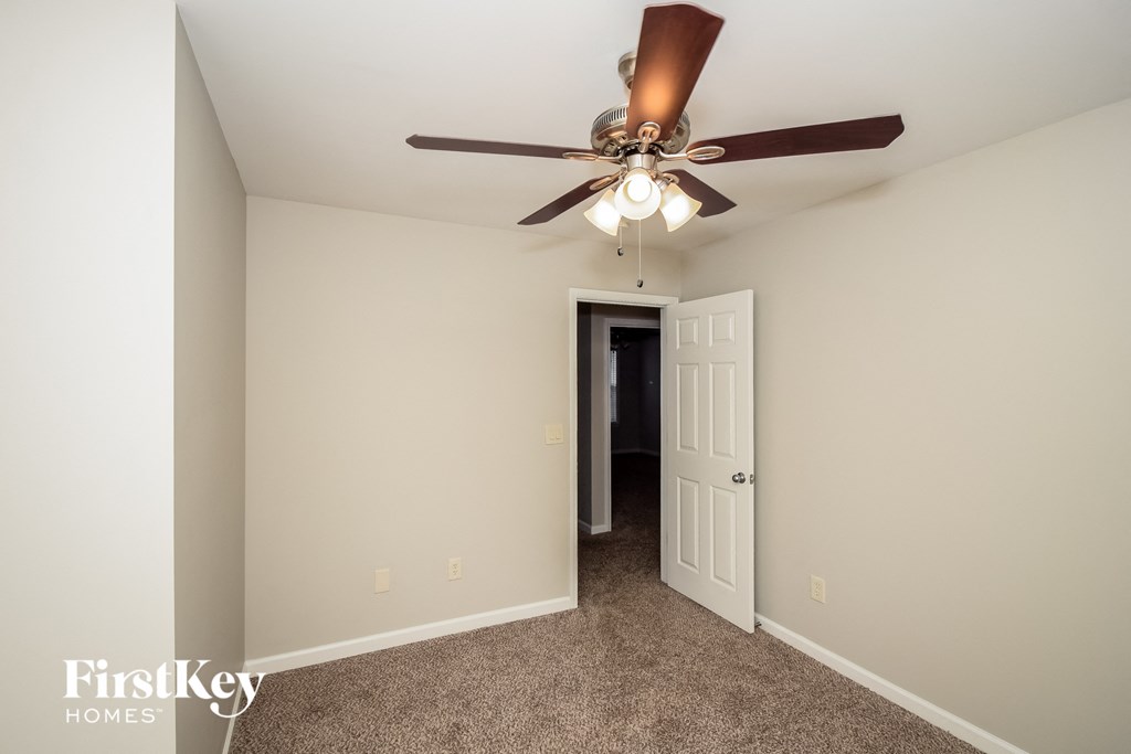 a bedroom with a ceiling fan and a door to a closet