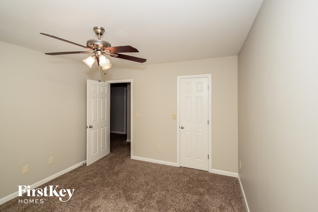 a bedroom with a ceiling fan and a closet