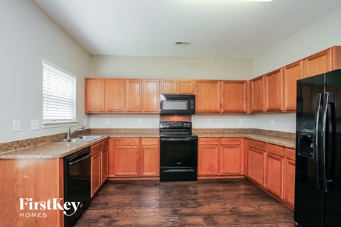 A kitchen with wooden cabinets and black appliances.