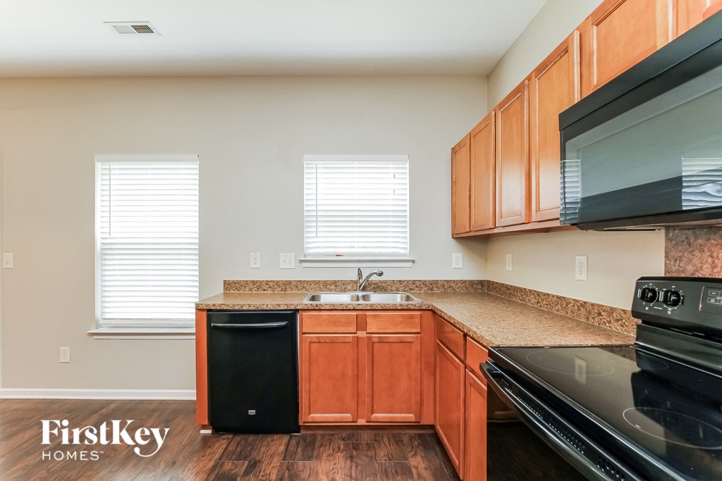 A kitchen with wooden cabinets and black appliances.