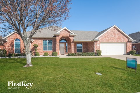 a house with a lawn and a tree in front of it