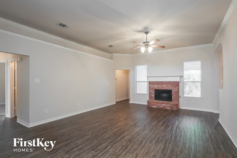 a living room with a fireplace and a ceiling fan